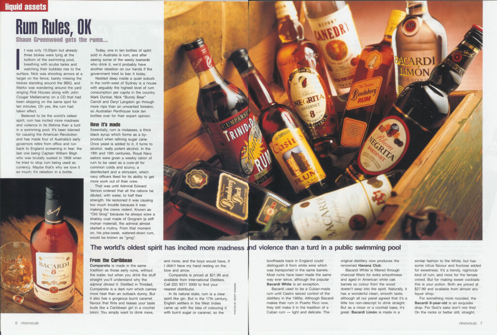 Various rum bottles like Trinidad and Casino Rum arranged inside a wooden crate with warm lighting.