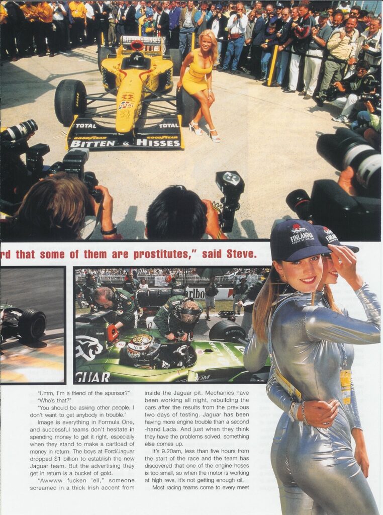 A blonde woman in a yellow dress sits on a yellow Formula One car as photographers and a crowd look on in the Paddock.1