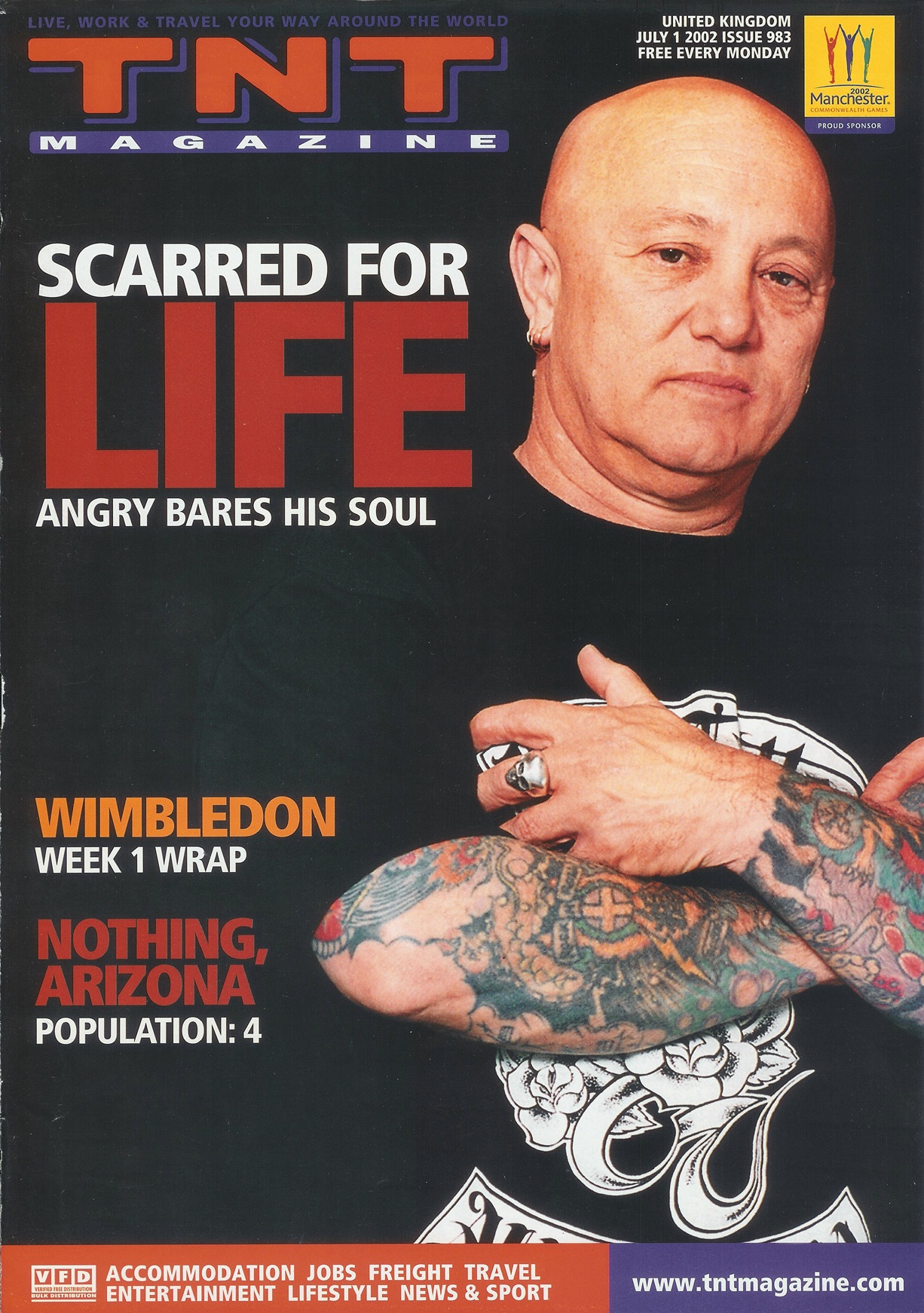 Portrait of bald man with tattoos on arms and hands, wearing a black shirt, on TNT Magazine's "Scarred for Life" cover.